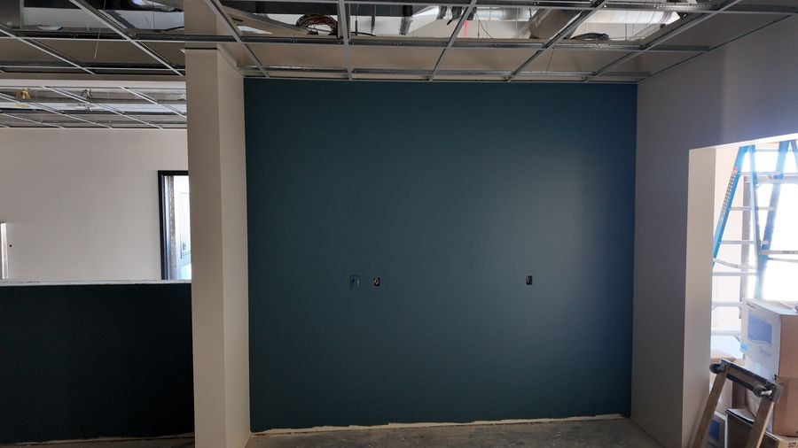 An office with a deep teal accent wall