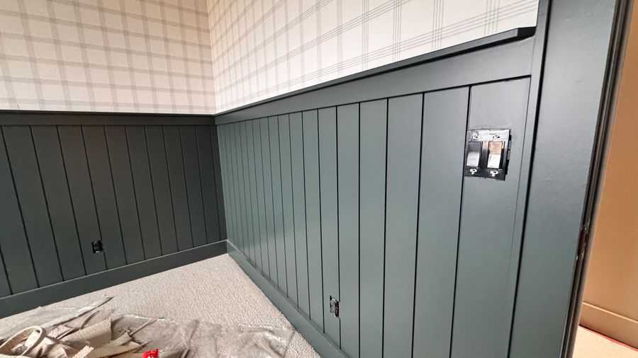 Close view of dark green board-and-batten wainscoting
