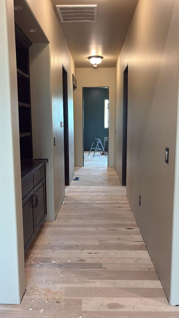 A long hallway with built-in cabinets and wood floors